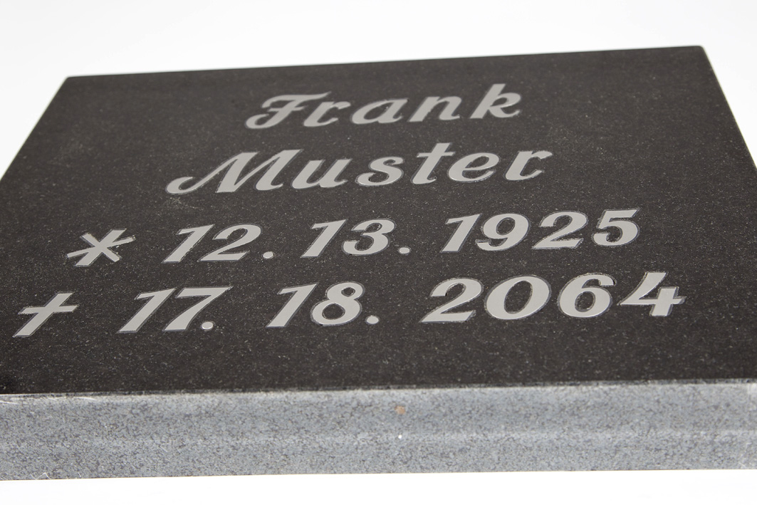 Tradition trifft Präzision – Intarsien-Inschrift von Steinmetz Bartels Grabtafel mit Intarsien-Inschrift aus schwarzem Granit, seitliche Ansicht